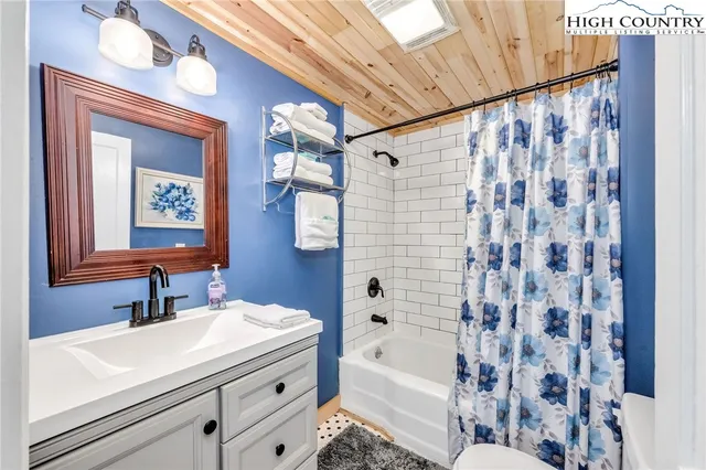 a bathroom with a sink a mirror a bathtub and shower