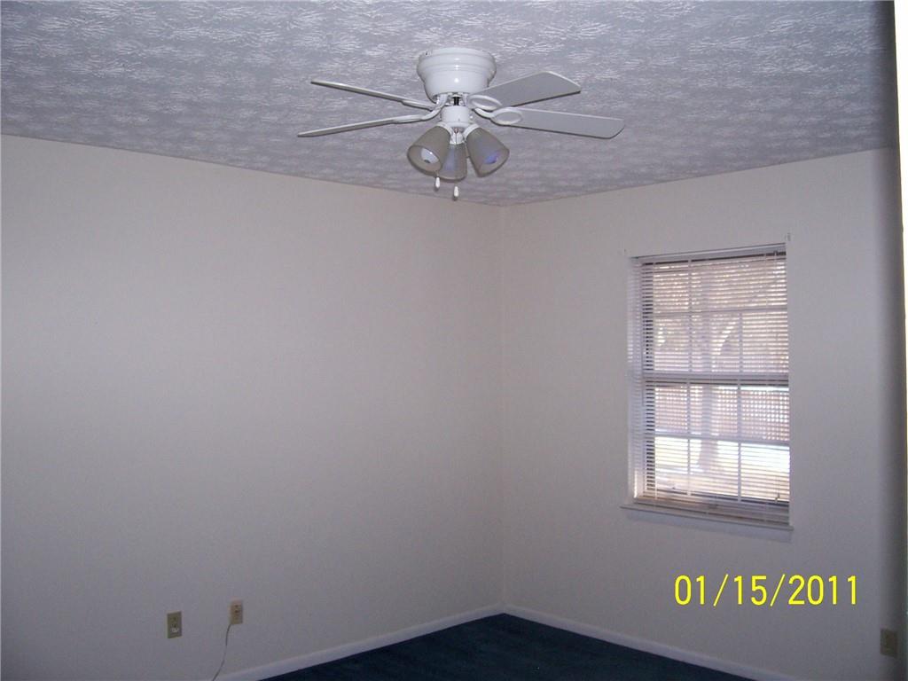 1235 Riverside Drive, Unit H1 Gainesville, GA 30501 - Photo 12 of 19 an empty room with a window and a ceiling fan