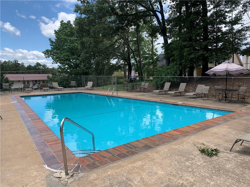 1235 Riverside Drive, Unit H1 Gainesville, GA 30501 - Photo 18 of 19 a view of a swimming pool with a patio and a yard