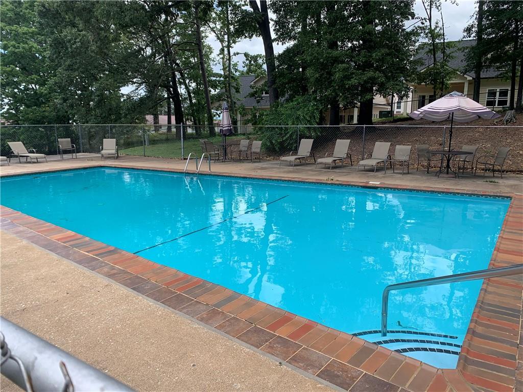 1235 Riverside Drive, Unit H1 Gainesville, GA 30501 - Photo 19 of 19 a view of a swimming pool with lawn chairs under an umbrella