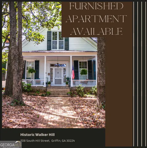 a view of a house with a tree in front of it