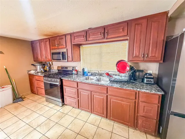a kitchen with granite countertop a sink and cabinets