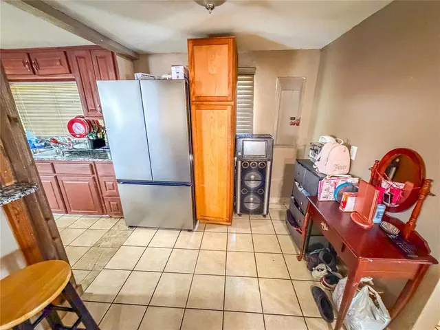 a kitchen with granite countertop a refrigerator and a stove top oven