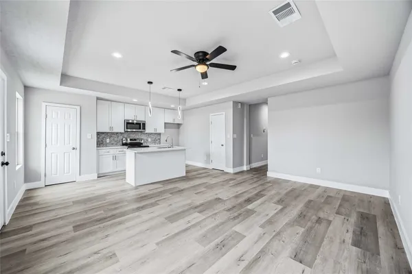 a view of kitchen with wooden floor and a refrigerator