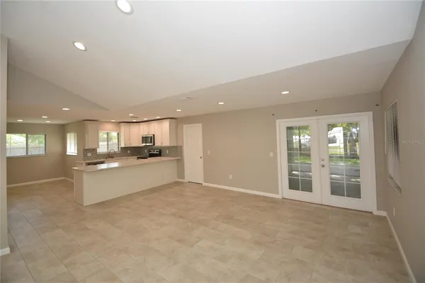 a large kitchen with kitchen island a sink a stove and a refrigerator with wooden floor