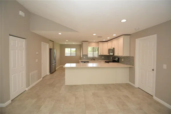 a view of kitchen with stainless steel appliances refrigerator oven and cabinets
