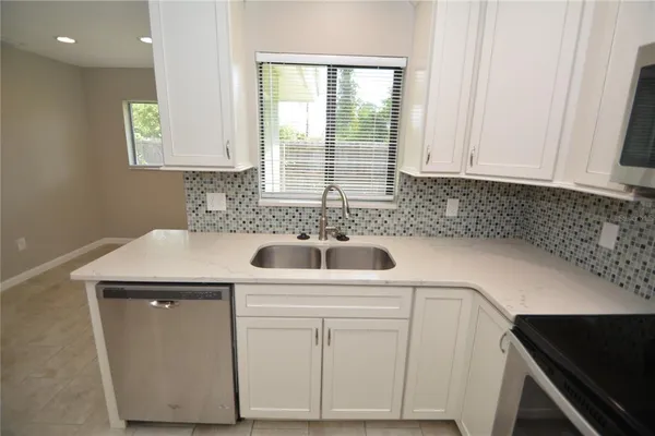 a kitchen with a sink cabinets and window