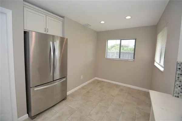 a view of kitchen with stainless steel appliances wooden floor and window