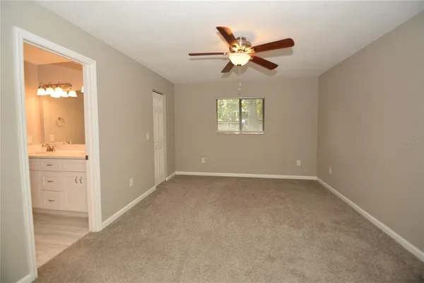 an empty room with windows and fan