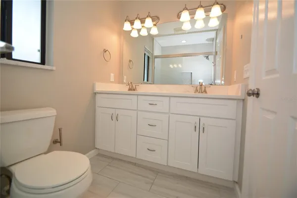 a bathroom with a toilet a sink a mirror and vanity