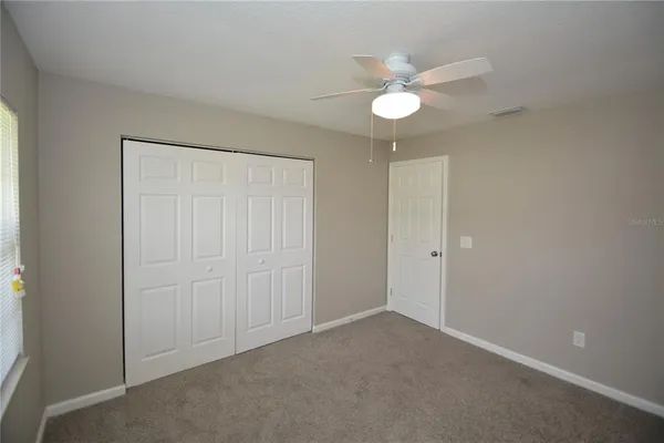 an empty room with a fan and a fan