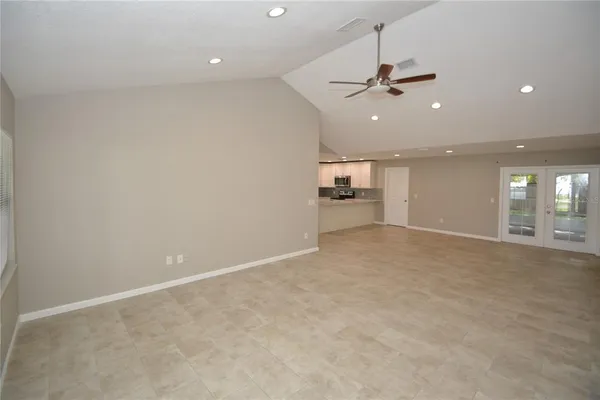 an empty room with windows and ceiling fan
