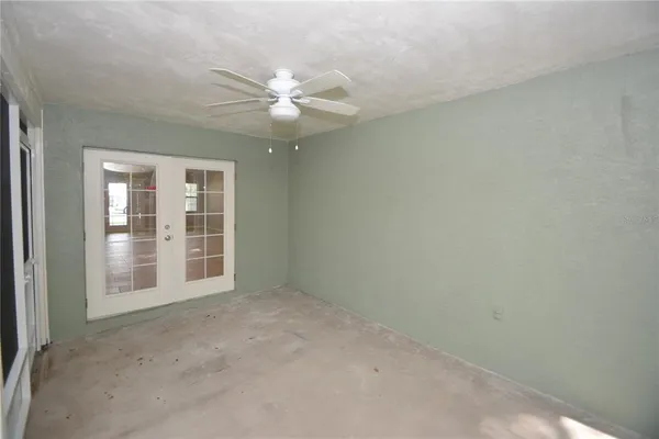 an empty room with windows and fan