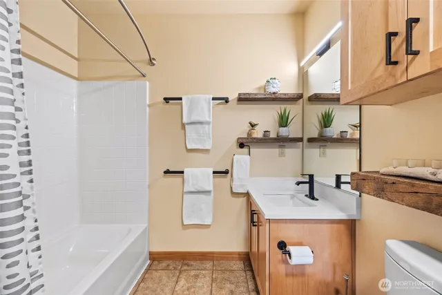 a bathroom with a bathtub sink and mirror