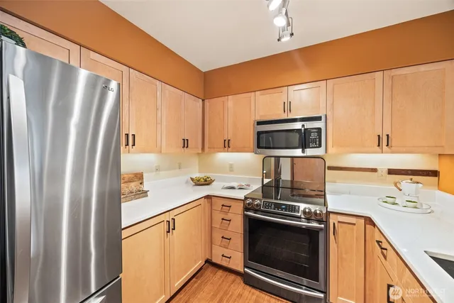 a kitchen with stainless steel appliances a stove a sink and a refrigerator