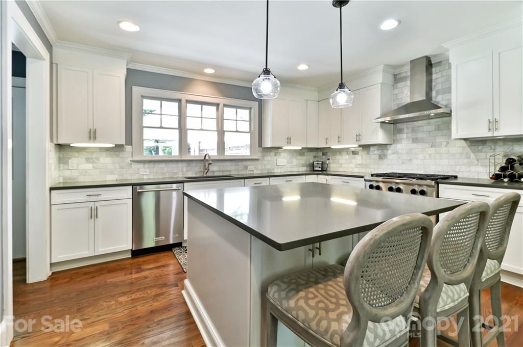 1901 Truman Road Charlotte, NC 28205 - Photo 13 of 39 a kitchen with stainless steel appliances granite countertop a sink a stove and chairs