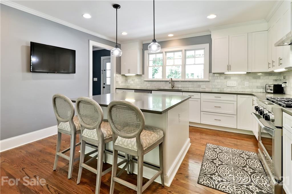 1901 Truman Road Charlotte, NC 28205 - Photo 15 of 39 a kitchen with granite countertop a table chairs microwave and sink