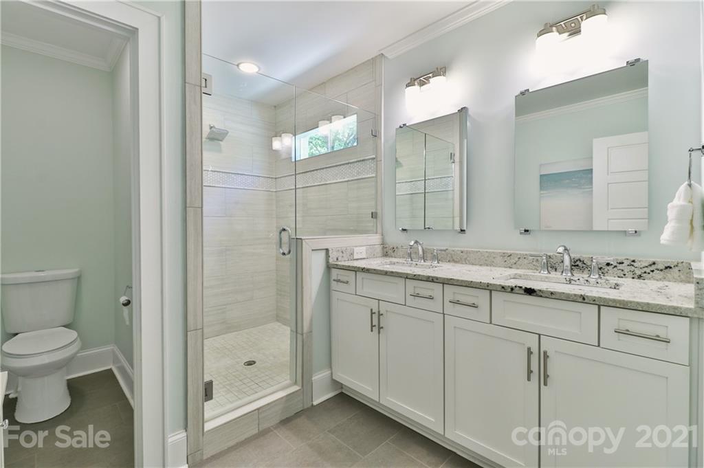 1901 Truman Road Charlotte, NC 28205 - Photo 17 of 39 a bathroom with a shower sink vanity and mirror