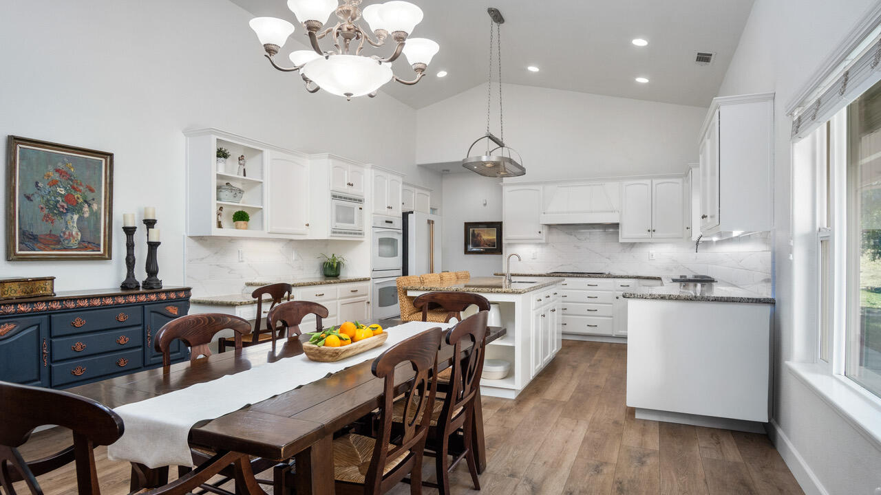 16657 Thomas Drive Springville, CA 93265 - Photo 13 of 37 a kitchen with stainless steel appliances granite countertop a stove a refrigerator a sink dishwasher a dining table and chairs with wooden floor