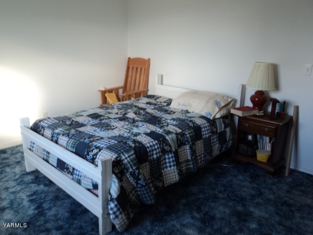 6701 East Beauchene Road Moxee, WA 98936 - Photo 12 of 27 a bed sitting in a bedroom next to a lamp