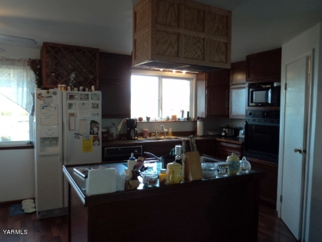 6701 East Beauchene Road Moxee, WA 98936 - Photo 4 of 27 a kitchen with a table chairs and a refrigerator