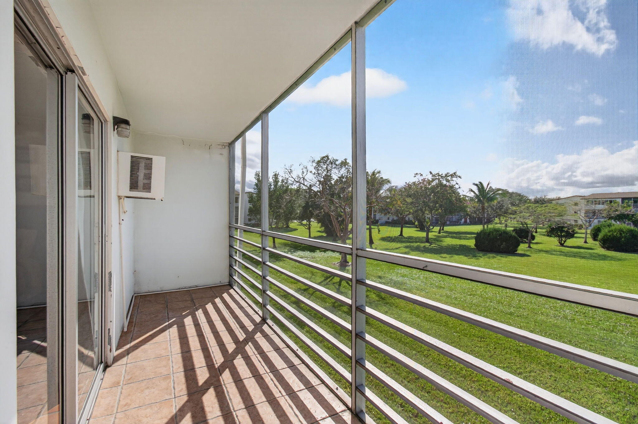 359 Brighton I Boca Raton, FL 33434 - Photo 20 of 34 a view of a balcony with floor to ceiling windows with wooden floor