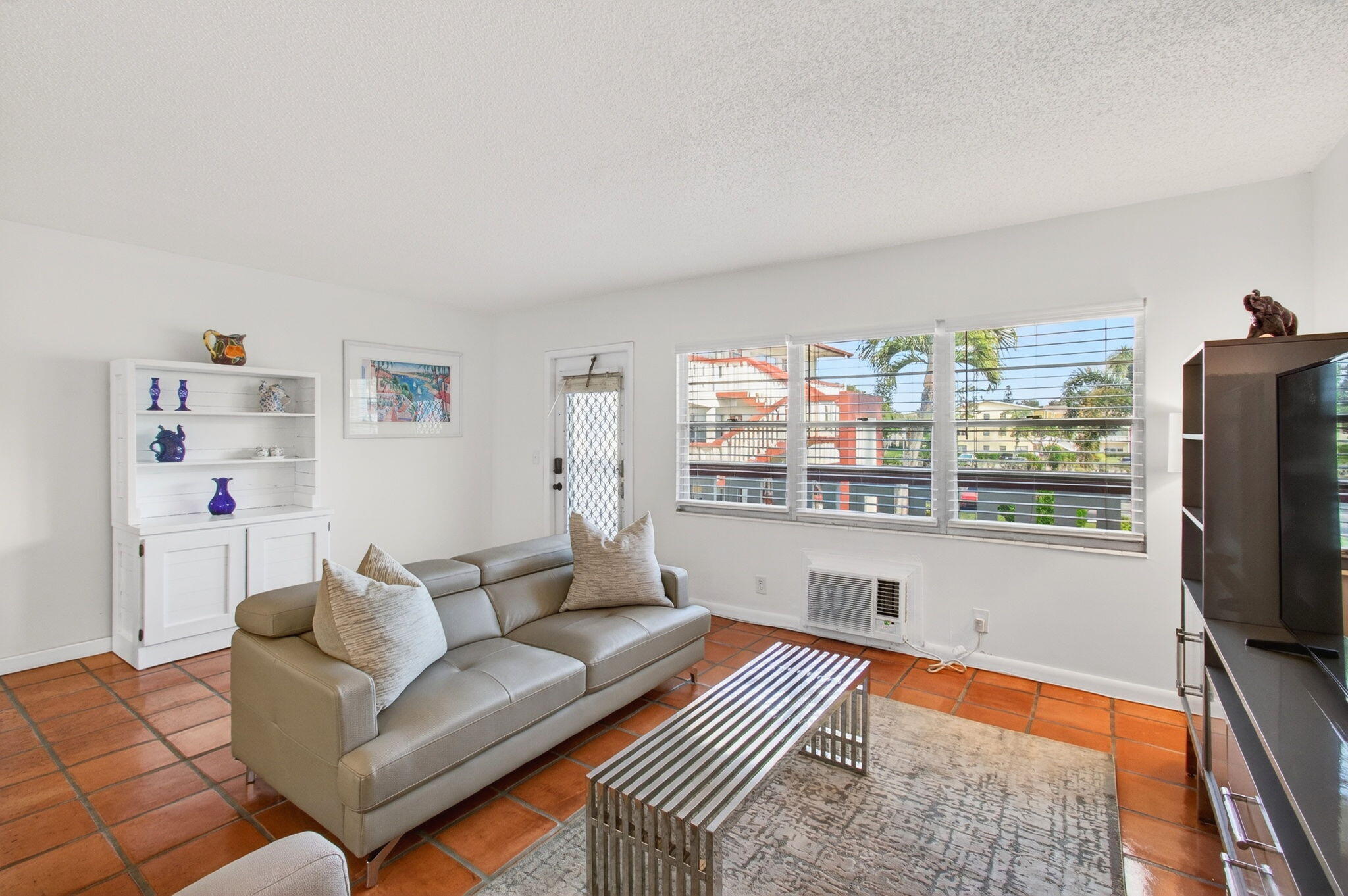 359 Brighton I Boca Raton, FL 33434 - Photo 8 of 34 a living room with furniture a flat screen tv and a floor to kitchen view