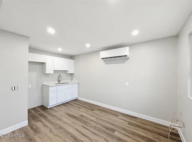 a kitchen with a refrigerator and white cabinets