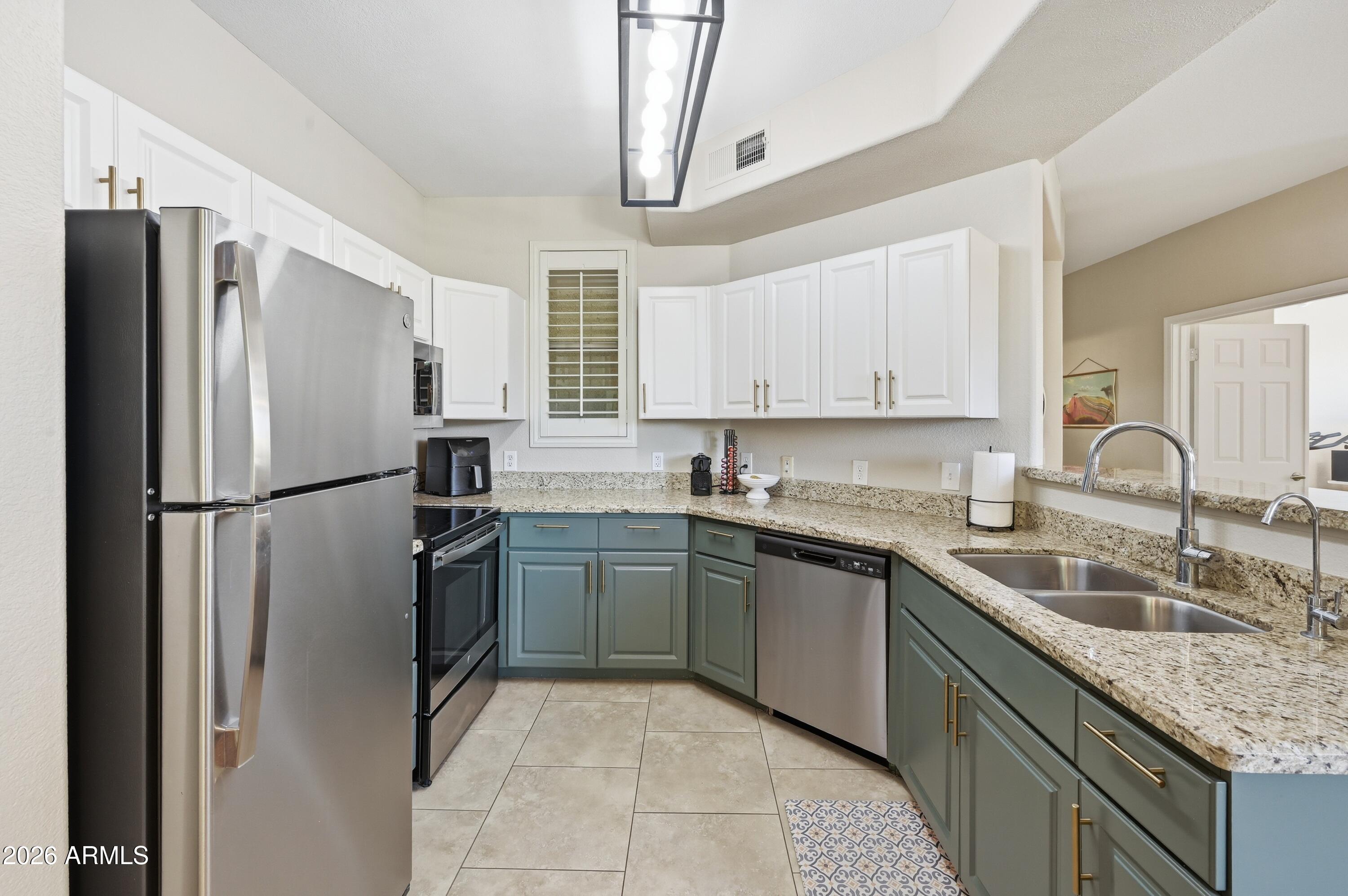 5303 North 7th Street, Unit 220 Phoenix, AZ 85014 - Photo 10 of 33 a kitchen with stainless steel appliances granite countertop a refrigerator sink and cabinets