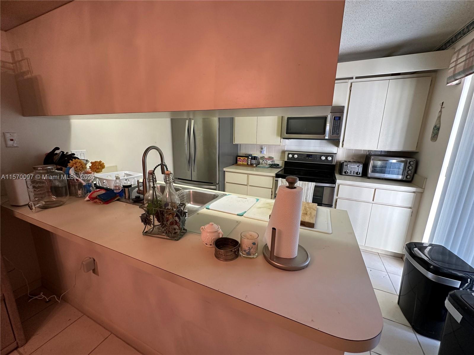2413 24th Court Jupiter, FL 33477 - Photo 15 of 32 a kitchen with a sink a stove and a microwave