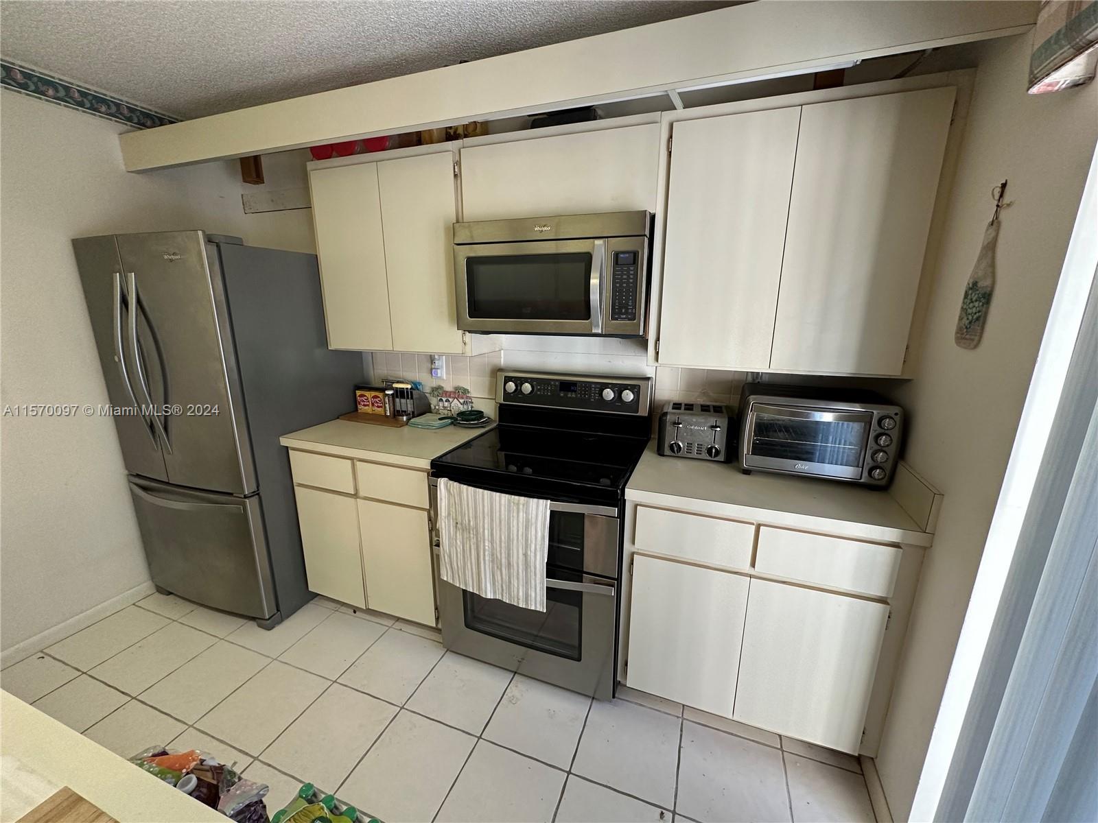 2413 24th Court Jupiter, FL 33477 - Photo 18 of 32 a kitchen with stainless steel appliances a refrigerator sink and microwave