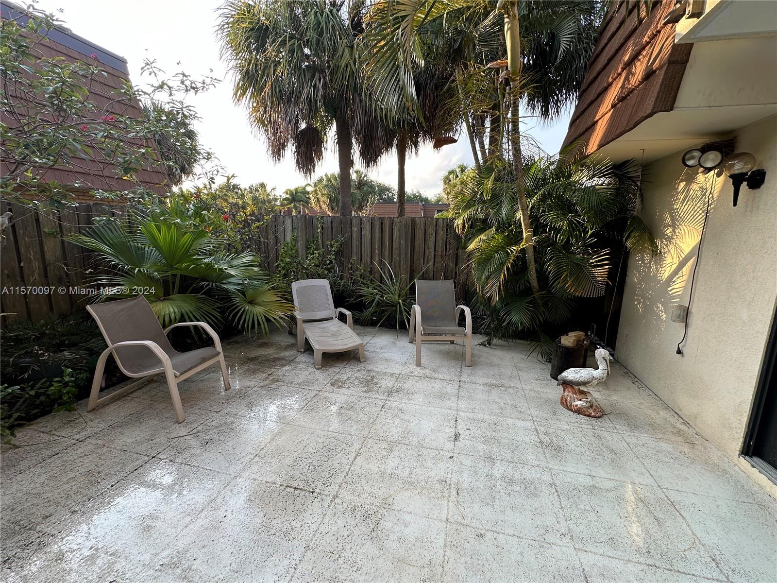 2413 24th Court Jupiter, FL 33477 - Photo 6 of 32 a backyard with a table and chairs and a barbeque