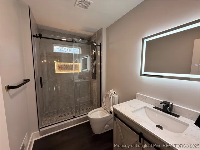 a bathroom with a sink toilet a mirror and shower