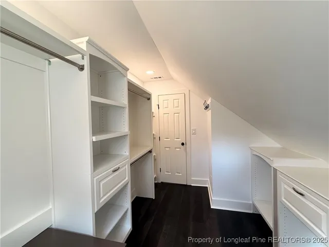 a view of walk in closet with empty racks