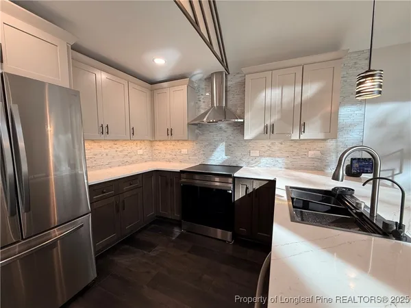 a kitchen with granite countertop a refrigerator stove and sink