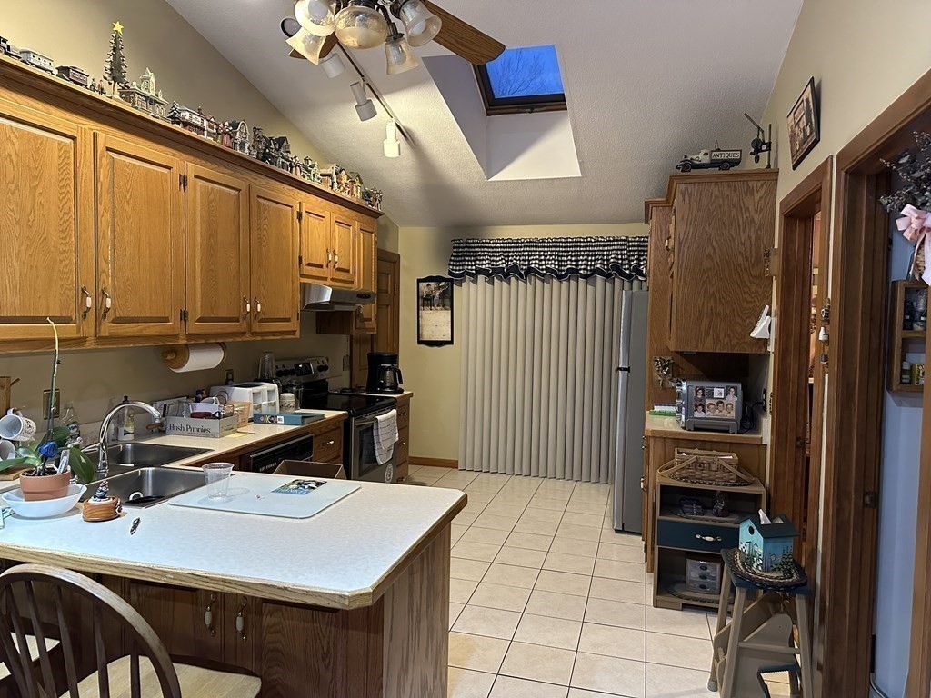 160 Osborne Road Ware, MA 01082 - Photo 8 of 28 a kitchen with a refrigerator a stove and a dining table with wooden floor