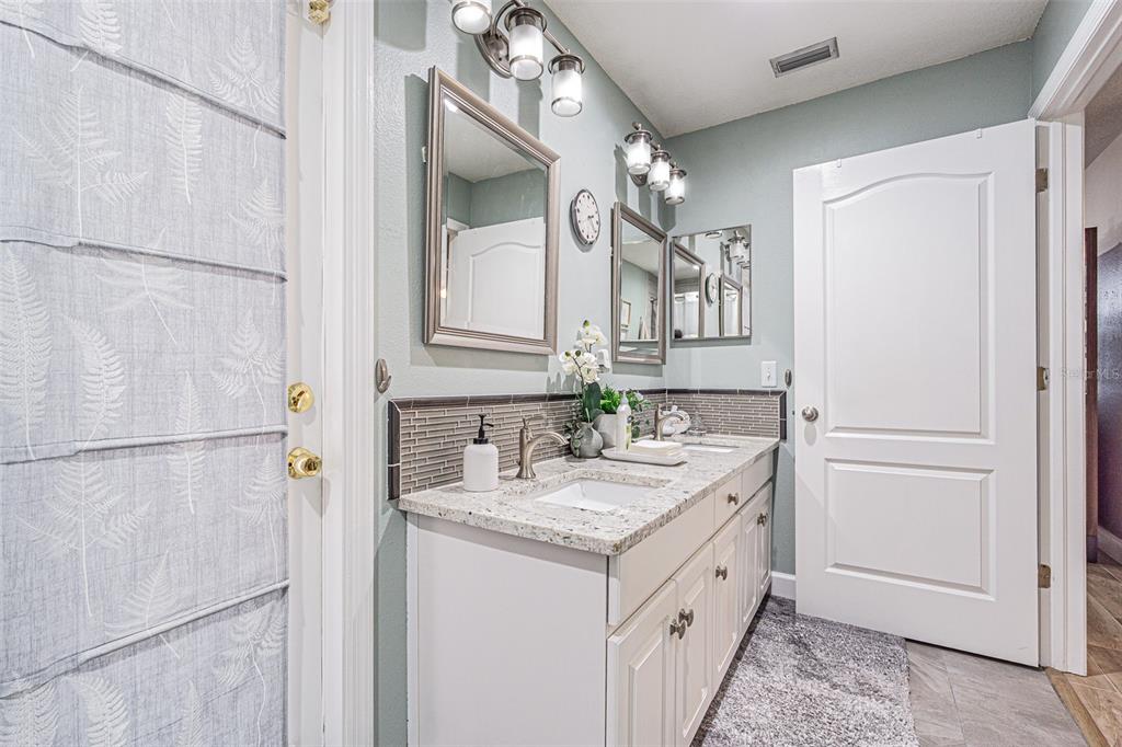 9809 La Rita Place Riverview, FL 33569 - Photo 12 of 59 a bathroom with a granite countertop sink a mirror and a shower