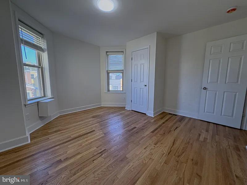 2111 Green Street, Unit 2R Philadelphia, PA 19130 - Photo 11 of 19 a view of an empty room with wooden floor and window