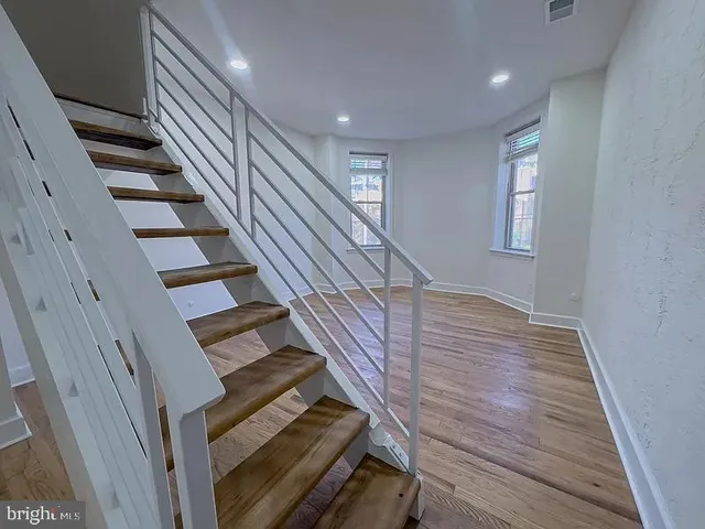 a view of entryway and hall with wooden floor