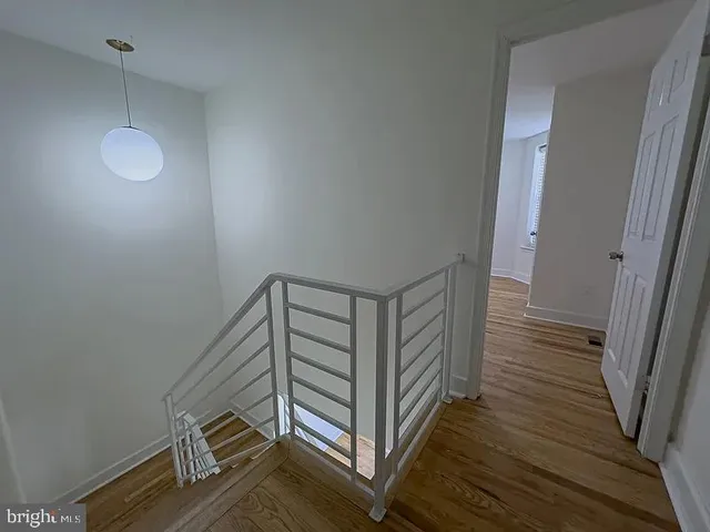 a view of a hallway with wooden floor and stairs