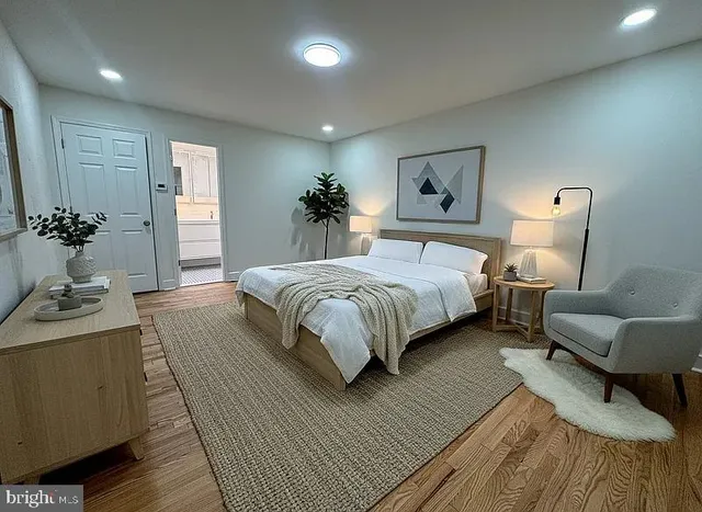 a bedroom with a large bed couch and a potted plant