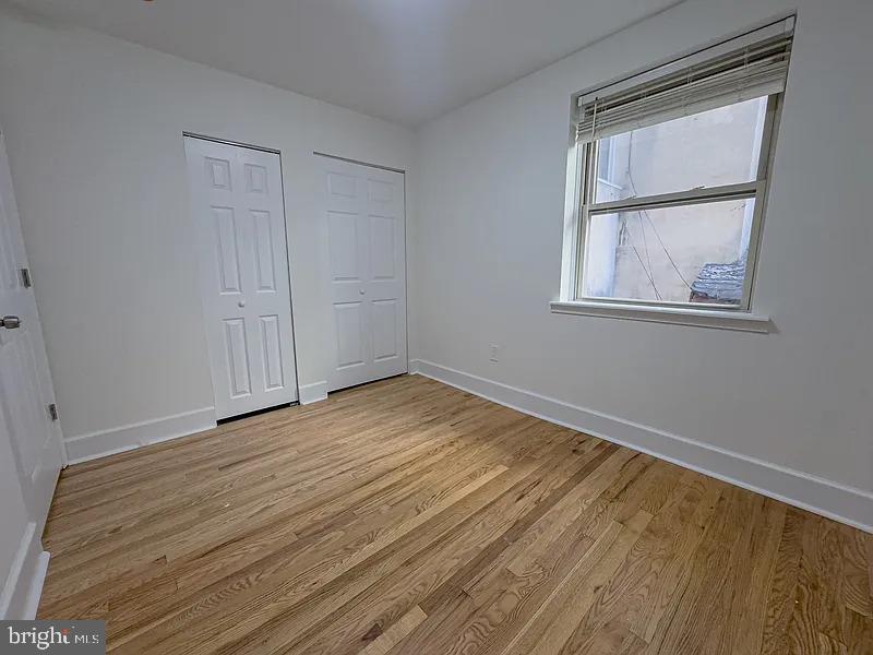 2111 Green Street, Unit 2R Philadelphia, PA 19130 - Photo 17 of 19 a view of an empty room with wooden floor and a window