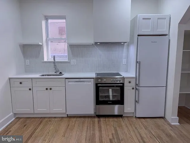 a kitchen with white cabinets and white appliances