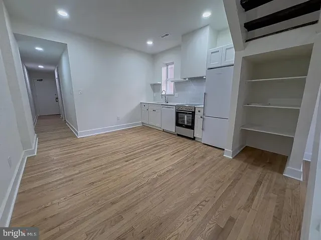 a view of kitchen with sink and refrigerator
