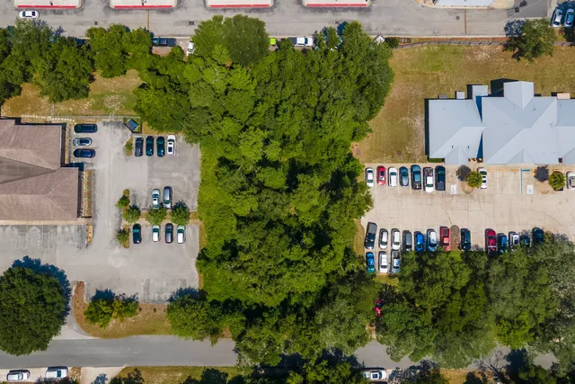 an aerial view of residential houses with outdoor space and trees all around