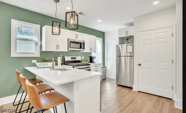 a kitchen with stainless steel appliances a stove refrigerator sink and microwave