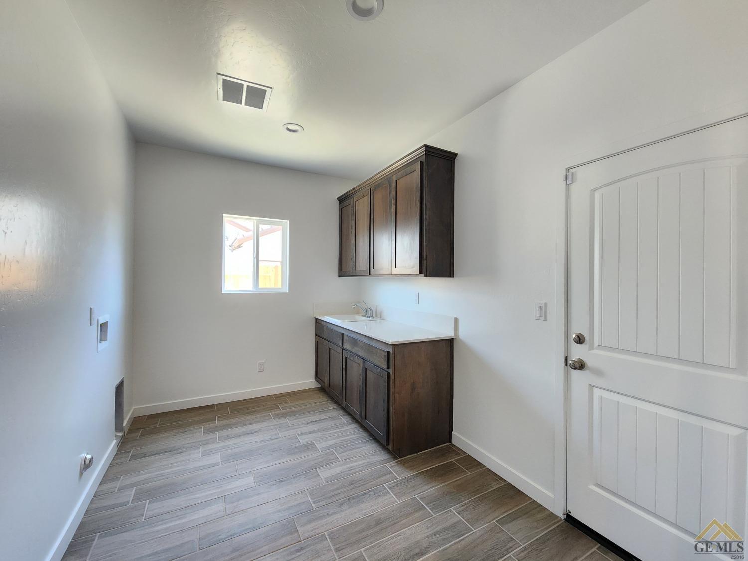 Undisclosed Address Bakersfield, CA 93313 - Photo 13 of 22 a kitchen with granite countertop white cabinets and wooden floor