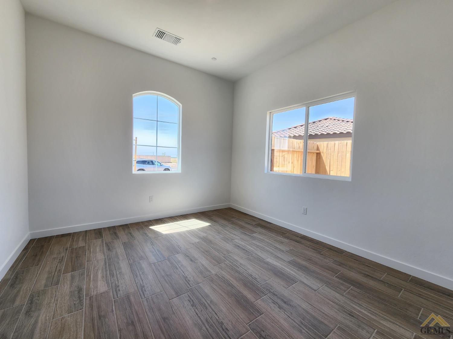 Undisclosed Address Bakersfield, CA 93313 - Photo 19 of 22 an empty room with wooden floor and windows