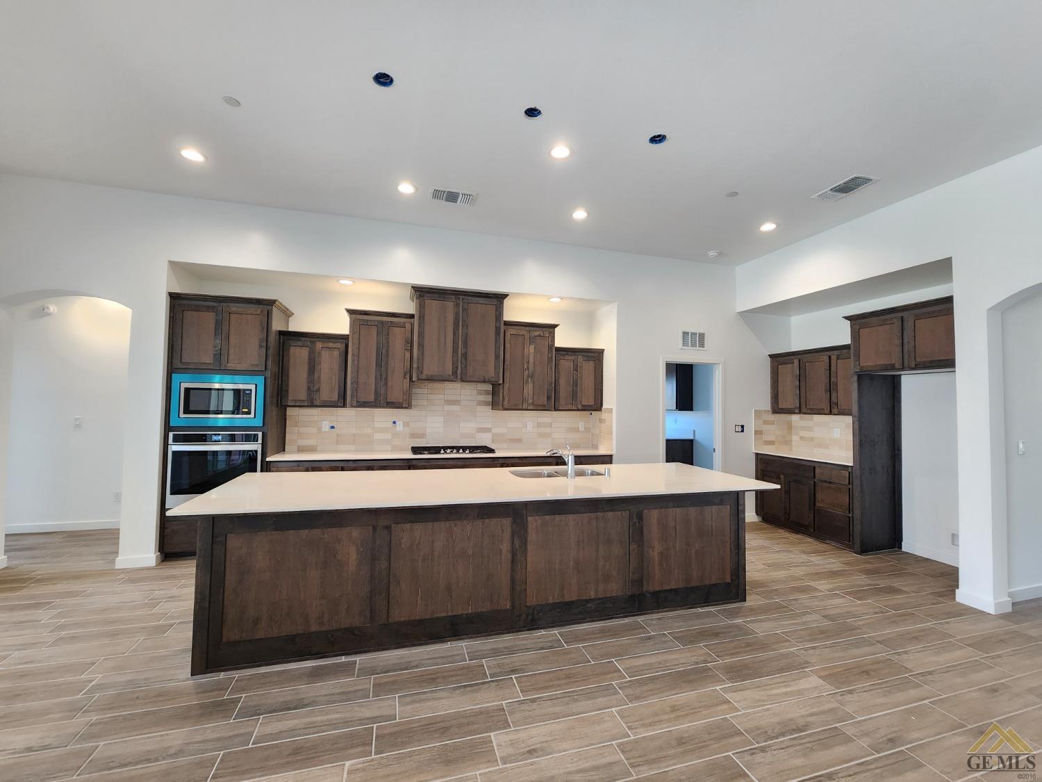 Undisclosed Address Bakersfield, CA 93313 - Photo 3 of 22 a large kitchen with stainless steel appliances a large counter top a stove and a refrigerator