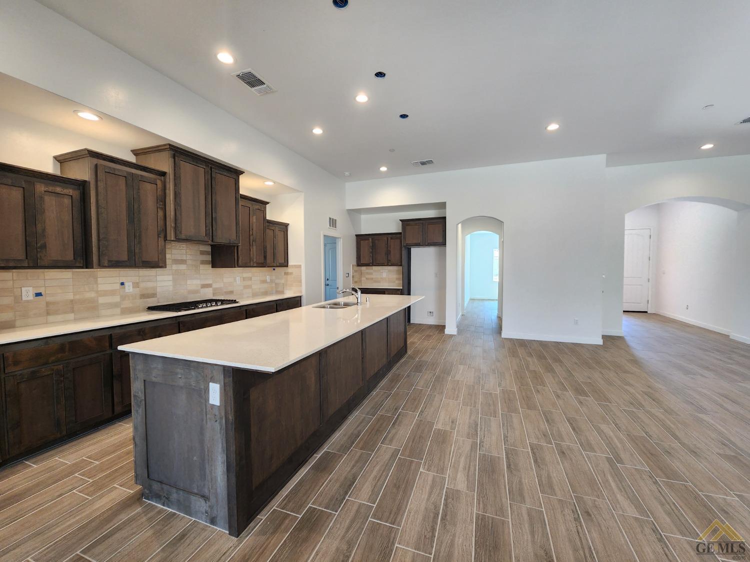 Undisclosed Address Bakersfield, CA 93313 - Photo 5 of 22 a large kitchen with stainless steel appliances granite countertop a large counter top a stove and a wooden floors